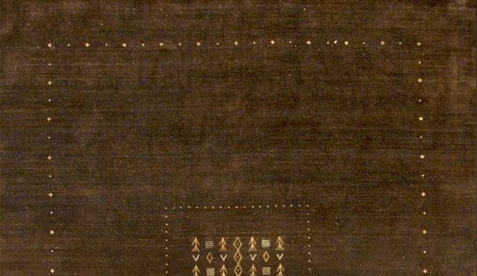 A brown rug has small geometric motifs.