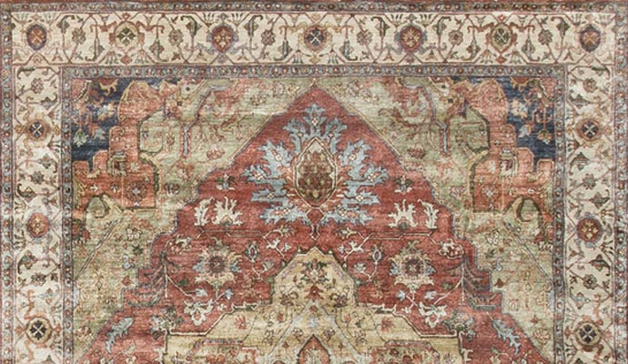 A red rug has a large medallion.