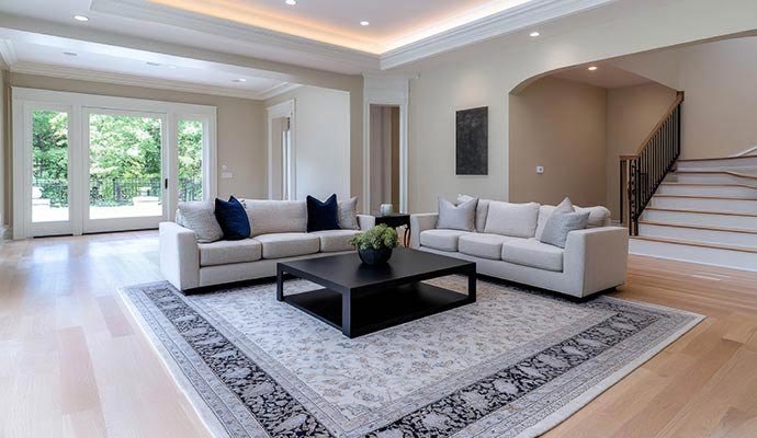 A spacious luxury living room featuring large patterned area rug