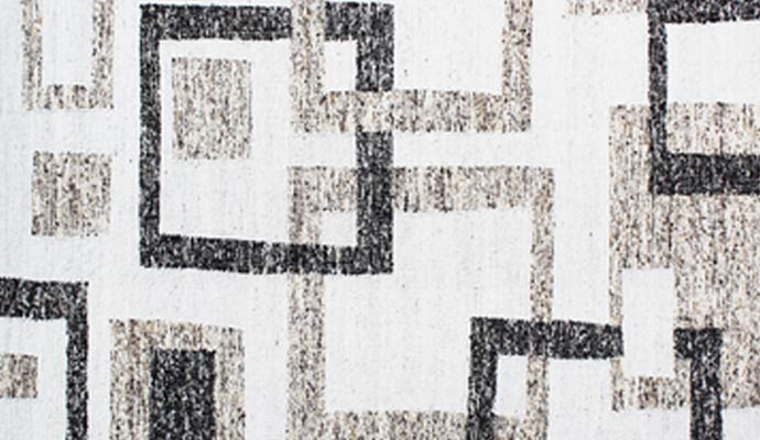 A white rug has interlocking squares.