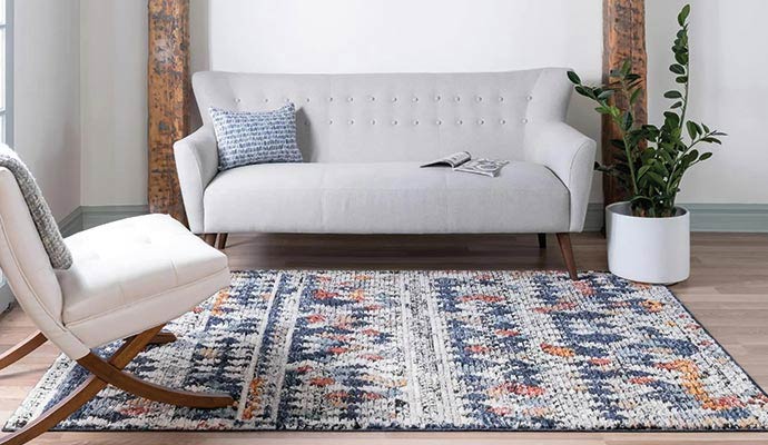 Textured bohemian area rug with blue and orange patterns in a bright minimalist living room
